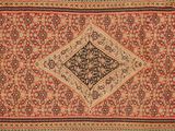 un tapis persan ancien orné d'un motif en losanges sur fond rouge
