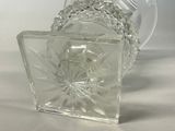 a clear glass vase with a clear base on a white surface
