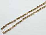 a close up of a gold chain on a white surface