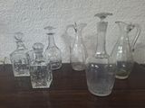bottles and glasses on a table with a white wall in the background