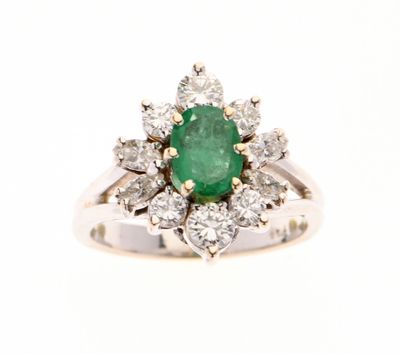 gros plan d'une bague en diamant et émeraude sur fond blanc