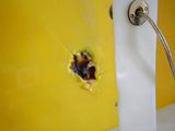 a hole in the side of a yellow wall