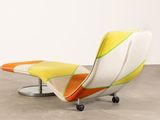 an orange and white chair with wheels on a concrete floor