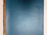 un livre bleu posé sur une table blanche