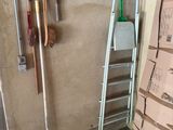 a pile of boxes and a ladder in the corner of a room