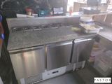 une photo d'une cuisine équipée d'appareils électroménagers en inox et de plans de travail en granit