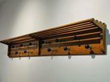a wooden shelf with a bunch of black knobs on it