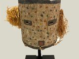 an image of a wooden mask with a face made out of straw
