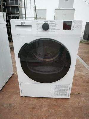 une machine à laver blanche posée par terre à côté d'une machine à laver blanche