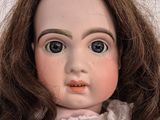 a close up of a doll wearing a pink dress