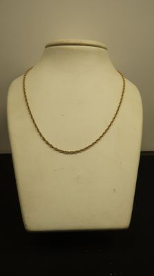 un gros plan sur un mannequin blanc auquel est attachée une chaîne