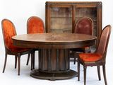 une table entourée de chaises, avec une bibliothèque en arrière-plan