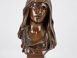 un buste en bronze représentant une femme portant un voile sur la tête