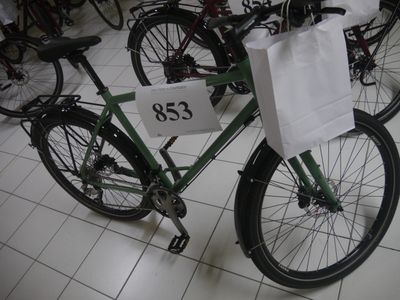 un vélo vert avec un sac blanc à l'arrière