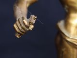 a close up of a statue of a woman holding a flower