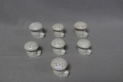 a lot of small white ceramic mushrooms on a table