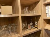 many glasses and bottles on the shelves in the room