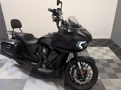 une moto noire garée sur un sol à damier