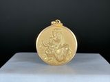 une image représentant une médaille d'or posée sur un socle blanc