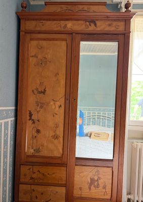 une photo d'une chambre aux murs bleus avec une armoire en bois