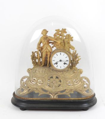 une horloge en or sous un dôme de verre sur une table