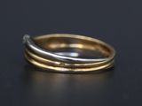 a close up of a gold and silver ring on a black surface