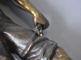 a bronze statue of a man with a glove on his hand
