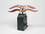 une image représentant un objet métallique muni d'un manche en bois, posé sur une boîte