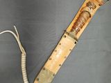 une photo d'un couteau à manche en bois posé sur une surface grise