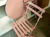 une chaise rose et une table rose dans une pièce