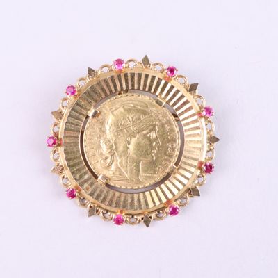 an image of a gold coin with pink stones in the center