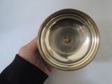 a person holding a silver bowl in their hand