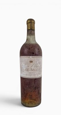 an old bottle of wine sitting on top of a white surface