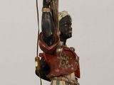 a statue of a man holding a candelier on a table