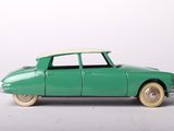 a green toy car that is sitting on a white surface