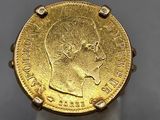 a close up of a gold coin on a white stand