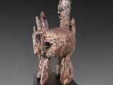 an image of a sculpture of a dog on a wooden base
