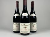 trois bouteilles de vin rouge posées côte à côte sur une table