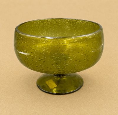 un saladier en verre vert posé sur une table