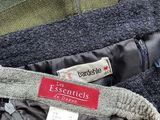 three jackets with labels on them sitting on a table