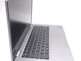 a silver laptop with a black keyboard on a white surface