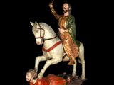 statue of a man on a horse with a man laying on the ground next to him
