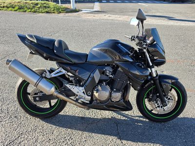 a black motorcycle parked in a parking lot on a sunny day