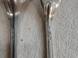 deux cuillères et une fourchette en argent sur une table
