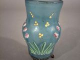 un vase bleu avec des fleurs posé sur une table