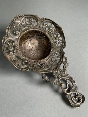 une cuillère en argent ancien ornée d'un motif décoratif sur le manche