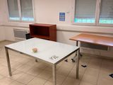 a white table with a cup on it in the middle of a room