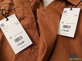 brown pants with price tags on them hanging on a hanger