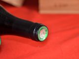 two bottles of wine sitting on a red cloth