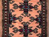 an old rug with fringes hanging on a wall